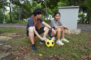 Male and female soccer players practice using the ball in the park field diligently and happily. photo