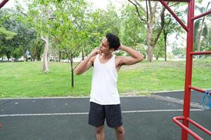 Asian man practicing gymnastics doing gymnastics bar and hoop exercises and stretching and resting for sports. photo