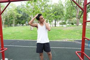 Asian man practicing gymnastics doing gymnastics bar and hoop exercises and stretching and resting for sports. photo