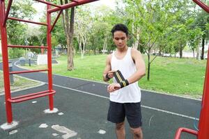 Asian man practicing gymnastics doing gymnastics bar and hoop exercises and stretching and resting for sports. photo
