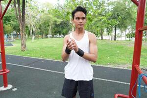 Asian man practicing gymnastics doing gymnastics bar and hoop exercises and stretching and resting for sports. photo