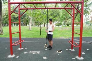 Asian man practicing gymnastics doing gymnastics bar and hoop exercises and stretching and resting for sports. photo