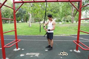 Asian man practicing gymnastics doing gymnastics bar and hoop exercises and stretching and resting for sports. photo