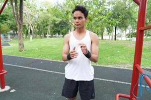 Asian man practicing gymnastics doing gymnastics bar and hoop exercises and stretching and resting for sports. photo
