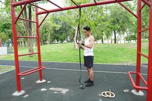 Asian man practicing gymnastics doing gymnastics bar and hoop exercises and stretching and resting for sports. photo