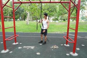 Asian man practicing gymnastics doing gymnastics bar and hoop exercises and stretching and resting for sports. photo