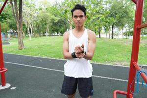 Asian man practicing gymnastics doing gymnastics bar and hoop exercises and stretching and resting for sports. photo