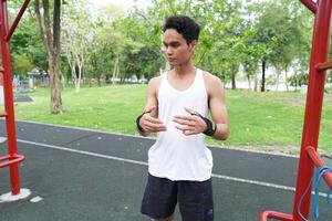 Asian man practicing gymnastics doing gymnastics bar and hoop exercises and stretching and resting for sports. photo