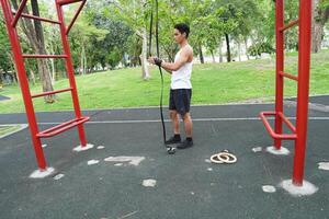 Asian man practicing gymnastics doing gymnastics bar and hoop exercises and stretching and resting for sports. photo