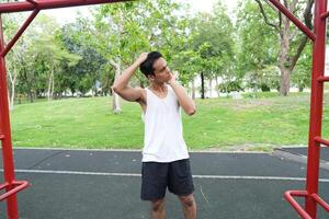 Asian man practicing gymnastics doing gymnastics bar and hoop exercises and stretching and resting for sports. photo