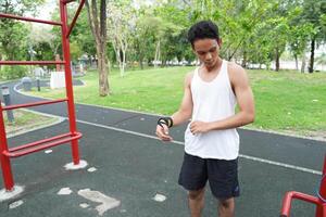Asian man practicing gymnastics doing gymnastics bar and hoop exercises and stretching and resting for sports. photo