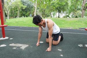 Asian man practicing gymnastics doing gymnastics bar and hoop exercises and stretching and resting for sports. photo