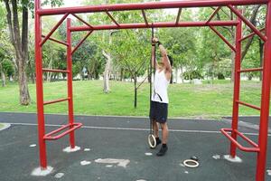 Asian man practicing gymnastics doing gymnastics bar and hoop exercises and stretching and resting for sports. photo