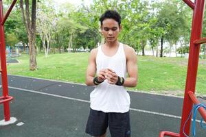 Asian man practicing gymnastics doing gymnastics bar and hoop exercises and stretching and resting for sports. photo