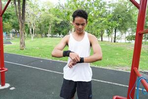 Asian man practicing gymnastics doing gymnastics bar and hoop exercises and stretching and resting for sports. photo