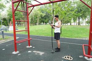 Asian man practicing gymnastics doing gymnastics bar and hoop exercises and stretching and resting for sports. photo