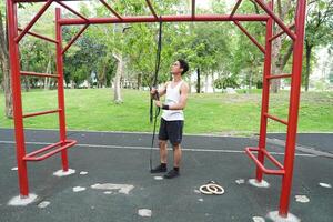 Asian man practicing gymnastics doing gymnastics bar and hoop exercises and stretching and resting for sports. photo