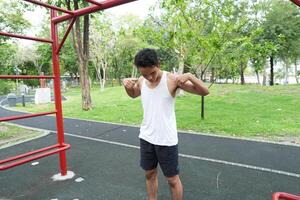 Asian man practicing gymnastics doing gymnastics bar and hoop exercises and stretching and resting for sports. photo