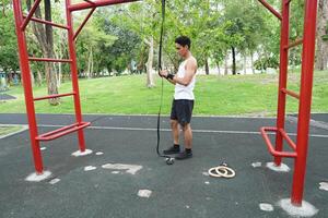 Asian man practicing gymnastics doing gymnastics bar and hoop exercises and stretching and resting for sports. photo