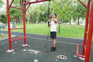 Asian man practicing gymnastics doing gymnastics bar and hoop exercises and stretching and resting for sports. photo