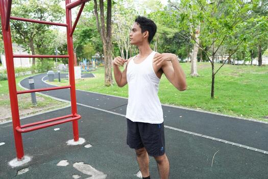 Asian man practicing gymnastics doing gymnastics bar and hoop exercises and stretching and resting for sports. photo