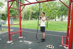 Asian man practicing gymnastics doing gymnastics bar and hoop exercises and stretching and resting for sports. photo