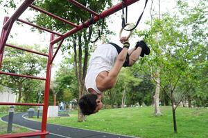 Asian man practicing gymnastics, doing gymnastics bar and hoop exercises and stretching, resting for sports. photo