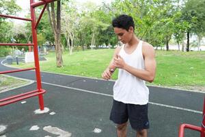 Asian man practicing gymnastics doing gymnastics bar and hoop exercises and stretching and resting for sports. photo