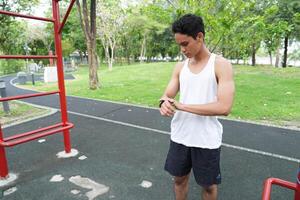 Asian man practicing gymnastics doing gymnastics bar and hoop exercises and stretching and resting for sports. photo