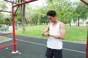 Asian man practicing gymnastics doing gymnastics bar and hoop exercises and stretching and resting for sports. photo