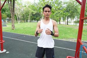 Asian man practicing gymnastics doing gymnastics bar and hoop exercises and stretching and resting for sports. photo