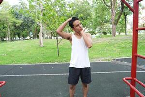 Asian man practicing gymnastics doing gymnastics bar and hoop exercises and stretching and resting for sports. photo