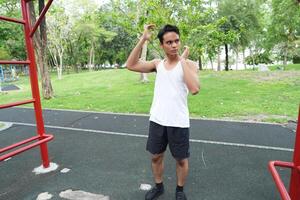 Asian man practicing gymnastics doing gymnastics bar and hoop exercises and stretching and resting for sports. photo