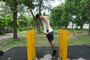 Asian man practicing gymnastics, doing gymnastics bar and hoop exercises and stretching, resting for sports. photo