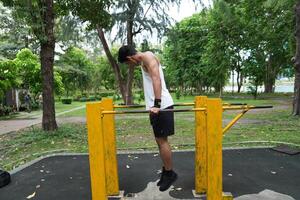 Asian man practicing gymnastics, doing gymnastics bar and hoop exercises and stretching, resting for sports. photo