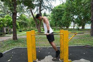 Asian man practicing gymnastics, doing gymnastics bar and hoop exercises and stretching, resting for sports. photo