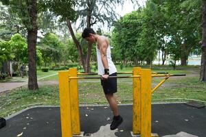 Asian man practicing gymnastics, doing gymnastics bar and hoop exercises and stretching, resting for sports. photo