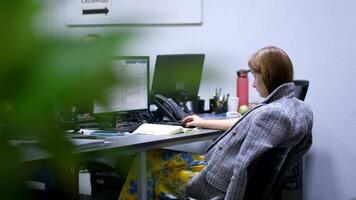 No heating girl in the office covered herself with a coat sitting working on the computer video