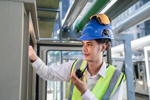 Industrial engineer adjusting pipeline valve with radio communication on construction site. Engineer on urban construction site using radio to coordinate with team on a sunny industrial rooftop. photo