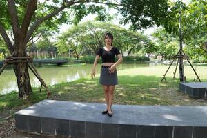 Asian woman dancing in the middle of a park photo