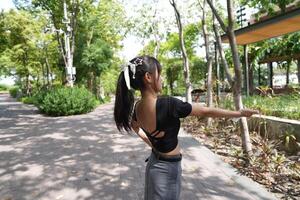 Asian woman dancing in the middle of a park photo