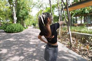 Asian woman dancing in the middle of a park photo