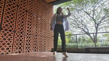 Asian girl dances freestyle hip-hop in an open space. photo