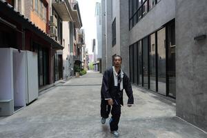 ASian man is dancing in hip hop style at outdoor space. Professional solo dancer is performing in public area. photo