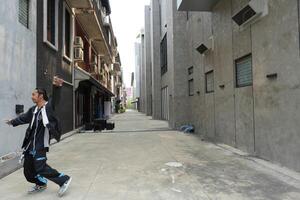 ASian man is dancing in hip hop style at outdoor space. Professional solo dancer is performing in public area. photo