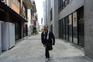 ASian man is dancing in hip hop style at outdoor space. Professional solo dancer is performing in public area. photo