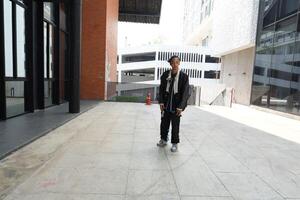 ASian man is dancing in hip hop style at outdoor space. Professional solo dancer is performing in public area. photo