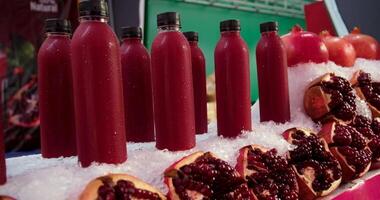 Pomegranate juice. Freshly squeezed pomegranate juice wave is flowing into a jug in slow motion video