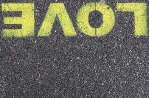 Road asphalt texture. Bitumen structure with painted love word. photo