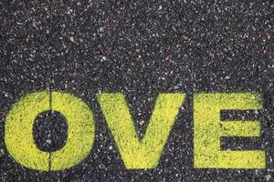 Road asphalt texture. Bitumen structure with painted love word. photo